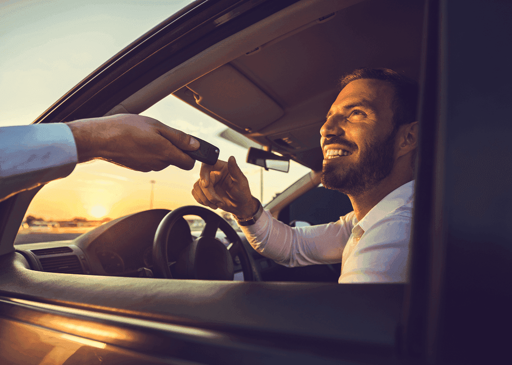Lächelnder Mann erhält Autoschlüssel.
