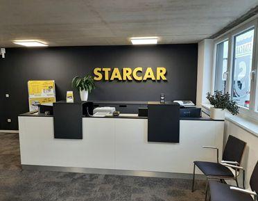STARCAR Autovermietung Station Würzburg Innenansicht mit Empfangstresen und Sitzgelegenheiten.