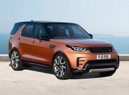 Oranger Land Rover Discovery auf Asphalt.